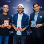 Three individuals holding different models of Nirvana by Boat earphones in front of a branded backdrop.
